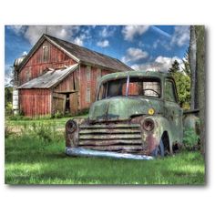 an old truck parked in front of a barn