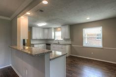 an empty kitchen with white cabinets and granite counter tops in a new construction home,