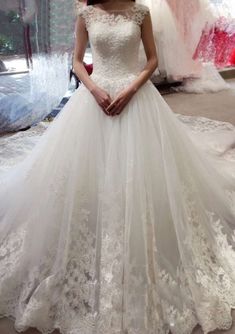 a woman in a white wedding dress is posing for the camera with her hands on her hips