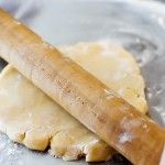 a person is rolling out dough on a cookie sheet