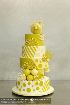 a three tiered cake with yellow flowers and polka dots on the bottom, sitting on a white plate