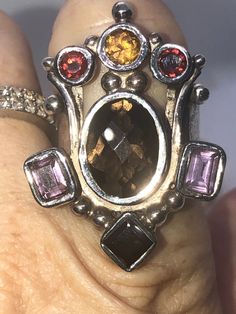 Amazing unique big gemstone ring smoky quartz, amethyst, Garnet and citrine. Ring sterling silver 925 Queen/ Royal Statement Size 10. Amazing ring. Extremely unique, I've never seen one like it. It truly feels like a medieval piece of jewelry that a queen or king would wear. Unusual and abstract piece. Would be perfect for a statement piece or even a Renaissance fair. The ring is well-made and solid. Signed 925. Elegant Sterling Silver Amethyst Ring, Unique Oval Amethyst Ring With Gemstone Accents, Unique Silver Topaz Gemstone Ring, Silver Crystal Ring With Accent Stones, Unique Silver Crystal Ring With Accent Stones, Unique Multi-stone Amethyst Ring For Gift, Unique Amethyst Multi-stone Rings, Unique Multi-stone Amethyst Ring, Unique Silver Crystal Ring With Stones