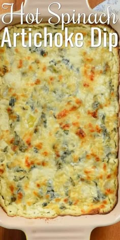 hot spinach artichoke dip in a pink casserole dish on a wooden table