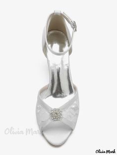 a women's white high heeled shoe with a bow on the ankle and an embellished buckle