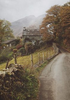 an old country road with a house on the side