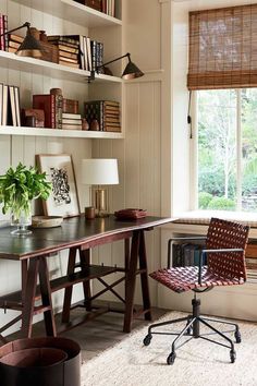 a home office with bookshelves, desk and chair in front of a window