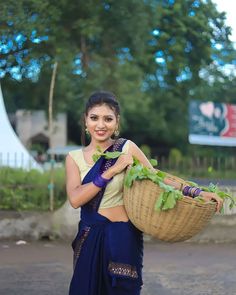 a woman holding a basket full of lettuce in her hands and smiling at the camera