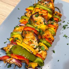 grilled chicken and vegetable skewers on a blue platter