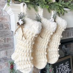 two knitted stockings hanging from a mantel