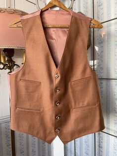 This is a beautiful vest, made of a wool blend in light rust/copper brown. It has the original decorative buttons in the front and four front pockets, and is fully lined. There are no labels. The measurements, taken with the vest lying flat, are: shoulder to shoulder, 14 inches; armpit to armpit, 21 inches; length, 25 inches in front and 20 1/2 inches in back; bottom edge, 19 inches. In very good condition. Cheap Fitted Brown Vest, Brown Wool Single-breasted Three-piece Suit, Brown Wool Three-piece Single Breasted Suit, Brown Single-breasted Wool Three-piece Suit, Brown Wool Three-piece Single-breasted Suit, Luxury Brown Vest With Pockets, Classic Brown Three-piece Suit For Fall, Brown Wool Three-piece Suit For Fall, Brown Wool Three-piece Suit For Winter