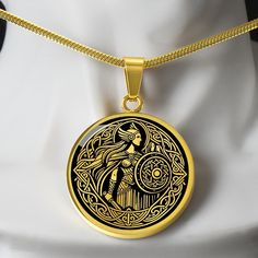 a gold necklace with an image of a woman holding a bird on it's back