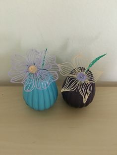 two decorative vases sitting on top of a wooden table