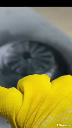 a yellow glove is in the sink with water