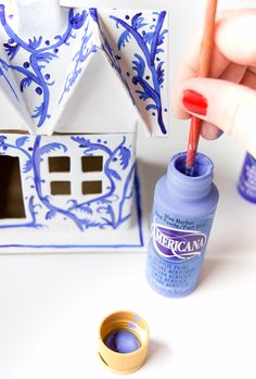 someone is painting the inside of a doll house with blue paint and a red pen