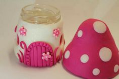 a pink and white mushroom next to a glass jar