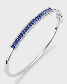 David Kord bangle bracelet.Solid 18-karat white gold with a polished finish.Blue sapphires in shared prong settings.Edges are decorated with diamonds.2.07 total sapphire carat weight.0.31 total diamond carat weight.Hinged opening eases dress.Imported White Gold Gemstone Bangle Fine Jewelry, Fine Jewelry White Gold Gemstone Bangle, White Gold Gemstone Bangle, Fine Sapphire Bangle Jewelry, White Gold Sapphire Diamond Bracelet, Luxury Sapphire Bangle Bracelets, Luxury Sapphire Bangle Bracelet, Luxury Sapphire Bangle Jewelry, Sapphire Bracelet With Prong Setting