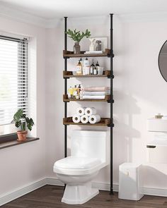 a white toilet sitting in a bathroom next to a shelf with rolls of toilet paper on it