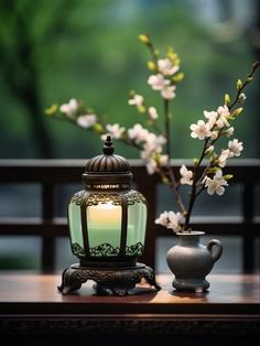 a vase with flowers and a lit candle on a table next to a lamp holder