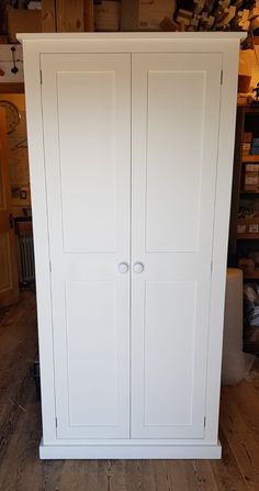 a white armoire sitting on top of a hard wood floor