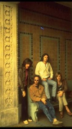 the group of people are posing for a photo in front of a wall with tiles on it