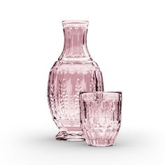 three pink glass vases sitting next to each other