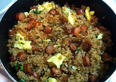 a pan filled with rice, sausage and eggs