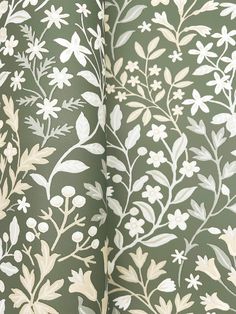 the wallpaper is green with white flowers and leaves on it's side,