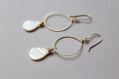 "These earrings are a little piece of ocean that you can always have. Shiny bright genuine white mother of pearl hoop earrings in 14k gold filled metal are a stunning piece of jewelry. Gold and white are the classic and elegant combination of colors. These are basic hoop earrings with a twist - shiny mother of pearl shell. With these earrings, it will be so easy to dress up even the simplest outfit. Total length approximately 3\" (7,5 cm) Mother of pearl is 18 x 13 mm. Gold filled is the next le Elegant Nickel-free Shell Earrings, Elegant Shell-shaped Jewelry With Ear Wire, Teardrop Mother Of Pearl Earrings For Gift, Teardrop Mother Of Pearl Earrings As Gift, Elegant Mother Of Pearl Hoop Earrings Gift, Beach Bridesmaid, Double Horn Necklace, Pearl Earrings Gold, Earrings Gold Hoop