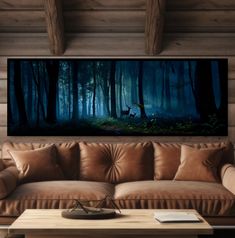 a living room with a couch, table and deer in the woods on it's wall