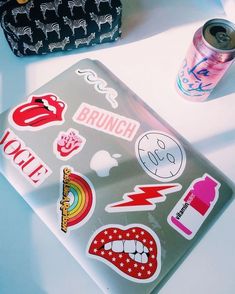 an open laptop computer sitting on top of a white table next to a can of soda