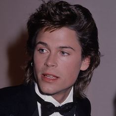 a close up of a person wearing a tuxedo and looking at the camera