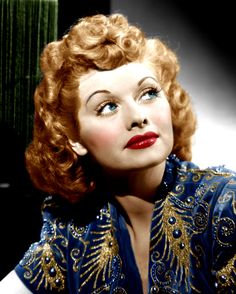 an old photo of a woman with red hair wearing a blue dress and gold trim