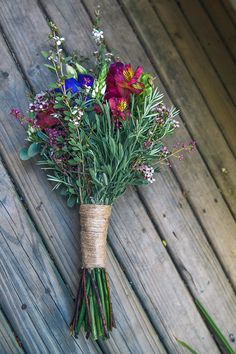 a bouquet of flowers tied to a wooden fence