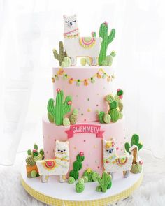 a pink cake with llamas and cactus on top