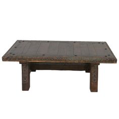 an old wooden coffee table with carvings on the top and bottom, against a white background