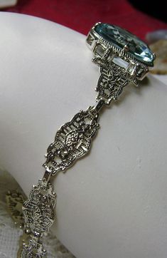 "<> (Made To Order) This is a brand new Victorian/Art Deco Reproduction filigree sterling silver gemstone bracelet. The gorgeous 6ct oval cut Simulated/man-made aquamarine gemstone is 14mm x 10mm x 6mm in dimension. Notice the beautiful craftsmanship of the filigree settings and links. This is a well made beautiful bracelet and it is ready to wear. The bracelet is adjustable and will fit from 7\" to 8.5.\"The color and clarity of each gemstone are excellent. A gift-box is included for safe Classic Formal Bracelets With Decorative Band, Classic Bracelets With Decorative Band For Formal Occasions, Vintage Formal Jewelry With Oyster Bracelet, Antique Oval Silver Bracelets, Antique Silver Oval Bracelets, Oval Filigree Art Deco Jewelry, Art Deco Oval Filigree Jewelry, Oval Art Deco Filigree Jewelry, Heirloom Oval Wedding Bracelets