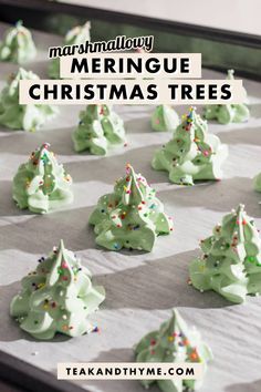 green christmas trees made from meringue and sprinkles on a baking sheet