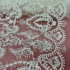 white embroidered lace on pink fabric