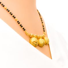 Discover opulence with our Dual Finish 22K Gold Triple Thali Mangal Sutra. Crafted in 22k gold, this exquisite piece features a weight of 15.8g, exuding luxury. The black bead stones and lustrous yellow gold finish make it a statement of high fashion. Necklace length: 20" with adjustable 1" links and a hook lock closure. PRODUCT DETAILS Gold Purity(karat): 22k Item Weight(grams): 15.8 Item Finish: Yellow Gold Stone: Black Bead Necklace Length: 20" Drop Length: 0.75" Adjustable Links: 1" Links Lo Black Necklace With Intricate Design For Festivals, Black Intricate Design Necklace For Festivals, Black Necklaces With Intricate Design For Festivals, Traditional Black Jewelry With Gold Beads, Black Bollywood Jewelry For Puja, Yellow Gold Jewelry With Polished Beads For Puja, Gold Jewelry With Black Beads For Festivals, Elegant Black Temple Necklace For Festive Occasion, Black Temple Jewelry For Ceremonial Occasions