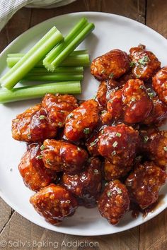 a white plate topped with meatballs and green beans next to celery sticks