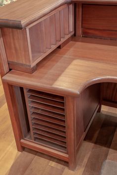 a wooden desk with shutters on the top and bottom section, in an office setting