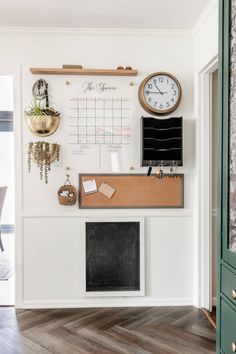 a desk with a clock, calendar and other items on it in front of a door