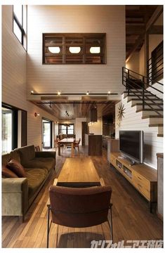 a living room filled with furniture and a flat screen tv sitting on top of a hard wood floor