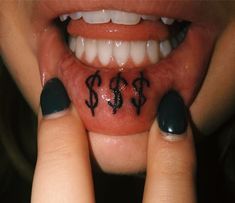 a close up of a person's mouth with money signs on her lip and tongue