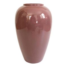 a large pink vase sitting on top of a white table