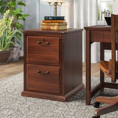 a wooden desk with two drawers and a chair next to it on top of a rug