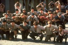 a group of young men standing next to each other on top of a brick road