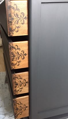 the drawers are made from wood and have intricate designs on them