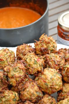 some food is sitting on a plate next to a pot of soup