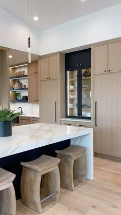 a kitchen with an island and stools next to it in the middle of the room